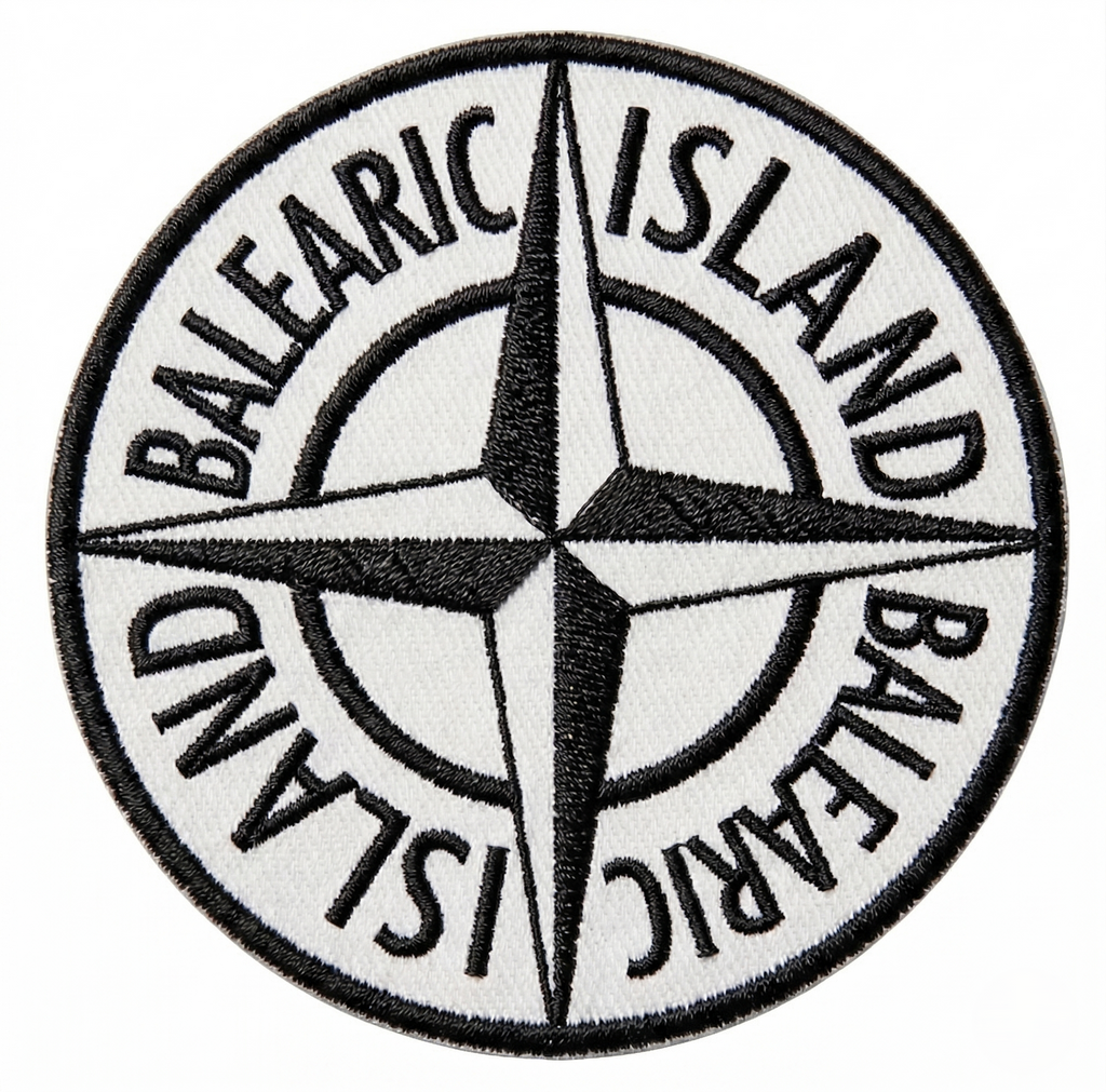 Balearic Blend T-shirt: Close-up of the hyper-realistic compass badge graphic print showing faux black and white stitching.