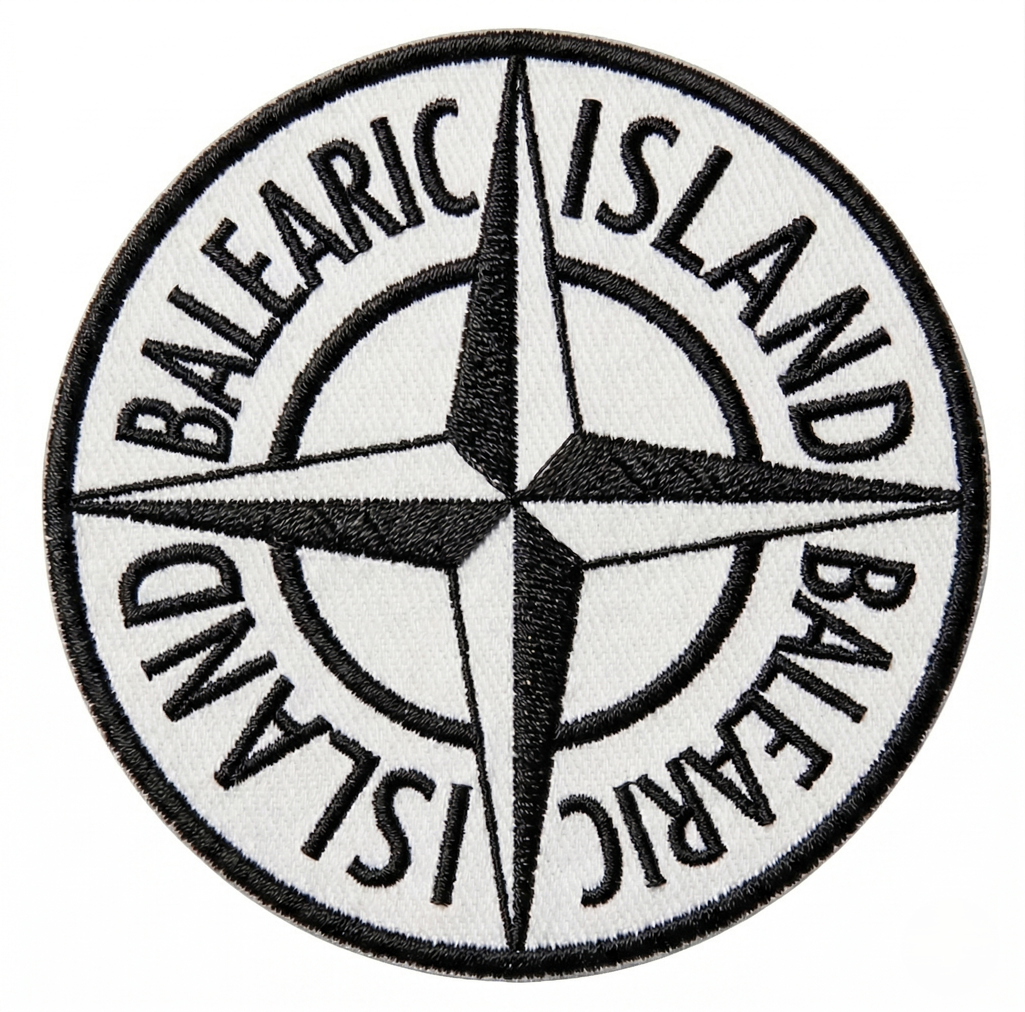 Balearic Blend T-shirt: Close-up of the hyper-realistic compass badge graphic print showing faux black and white stitching.