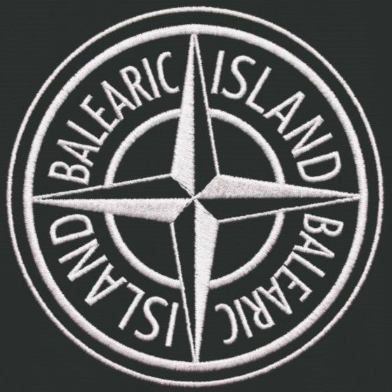 Balearic Blend T-shirt: Close-up of the inverted compass badge graphic print showing stark white faux stitching details.