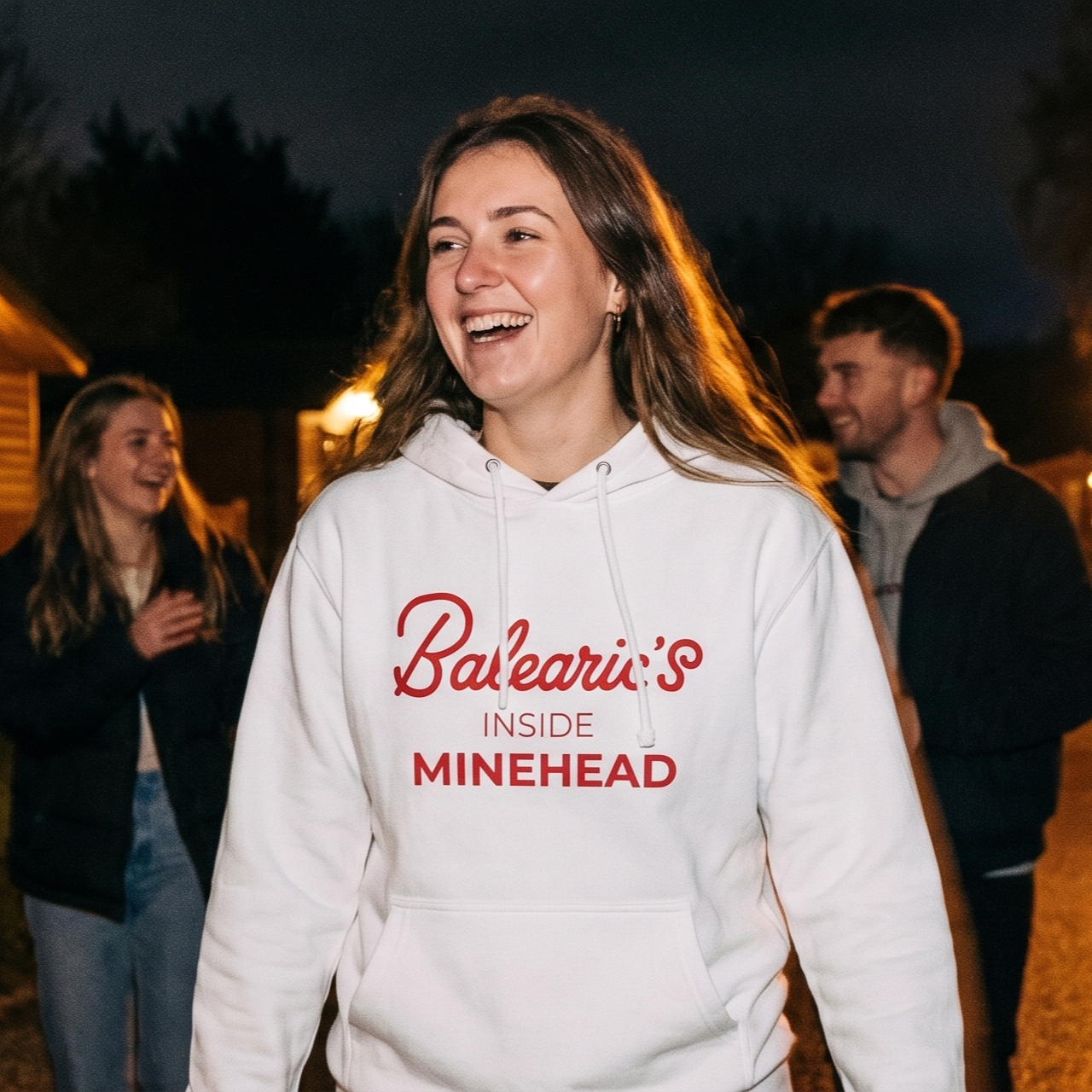 Person wearing a white hoodie with red text outdoors at night