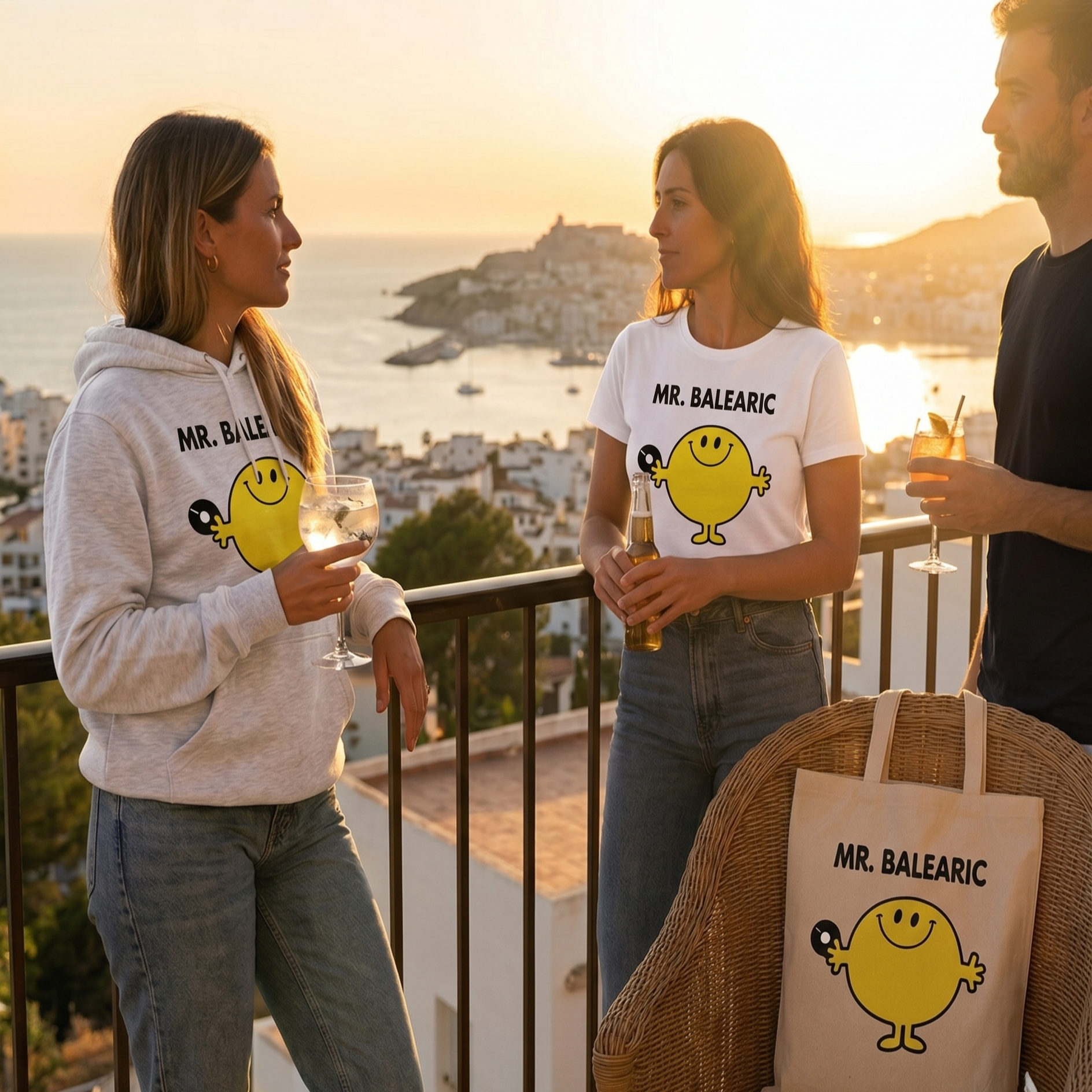 Three people on a balcony with 'MR. BALEARIC' branding, overlooking a scenic view on a Balearic island.