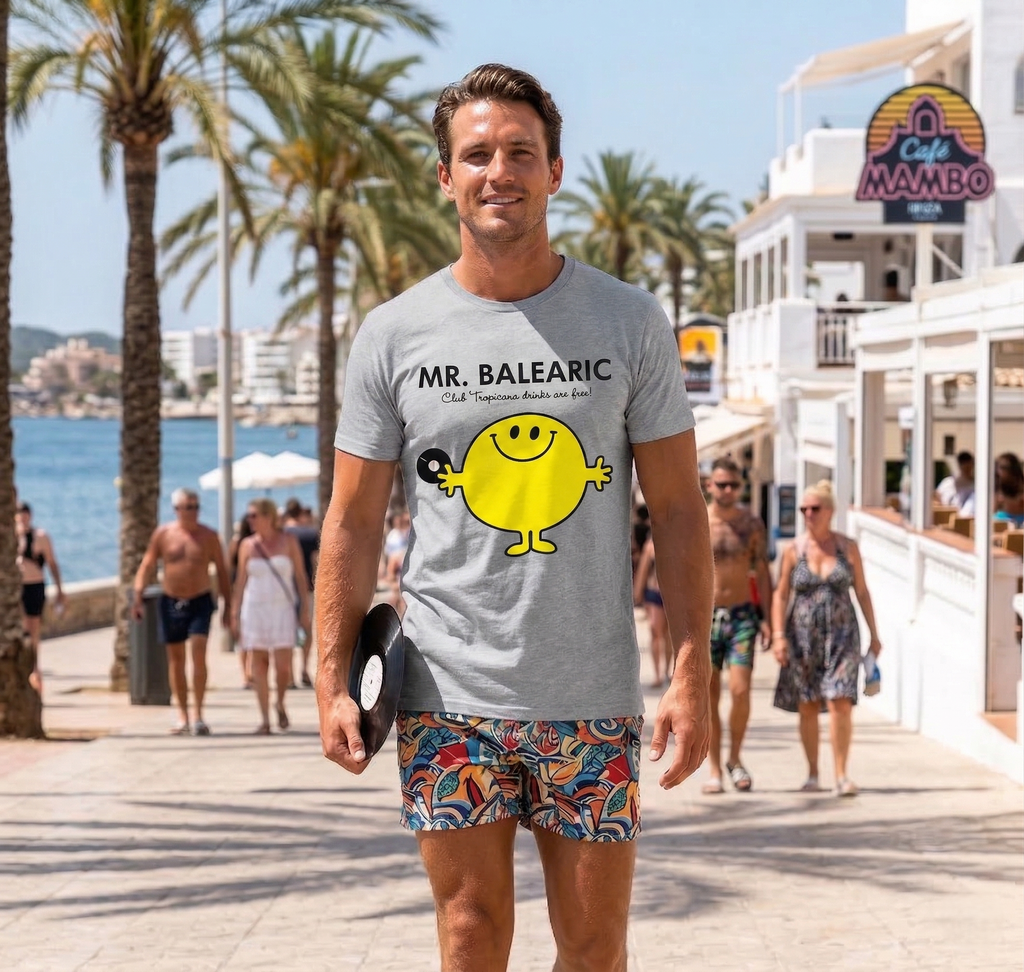 Balearic Blend T-shirt: Man in a grey Mr. Balearic graphic tee holding a vinyl record, walking along the sunny Ibiza waterfront near Café Mambo.