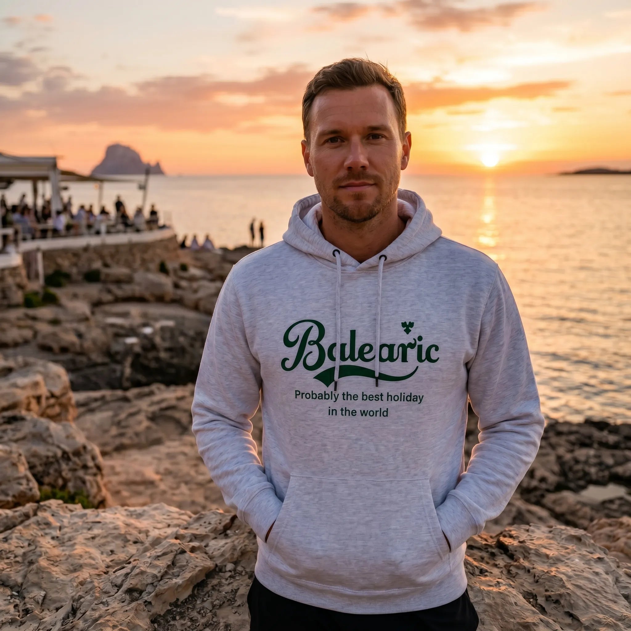 Model wearing Probably The Best Hoodie on the rocks by the beach at sunset